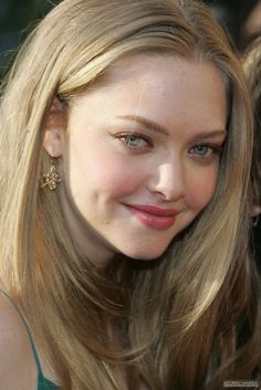 a woman with long blonde hair smiling at the camera