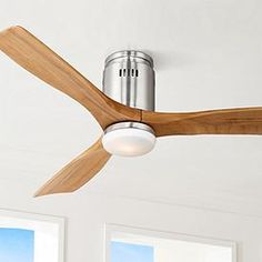 a ceiling fan with wooden blades and a light on the top is mounted in a white room