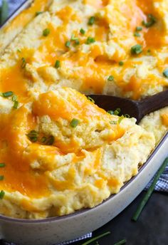 a casserole dish filled with mashed potatoes and topped with green chives