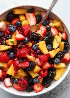 a white bowl filled with fruit and berries