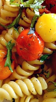 a pasta salad with tomatoes and other vegetables on the top is ready to be eaten