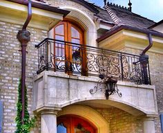 a balcony with wrought iron railing and an orange door