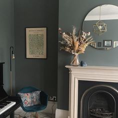 a living room filled with furniture and a piano in front of a fire place next to a fireplace