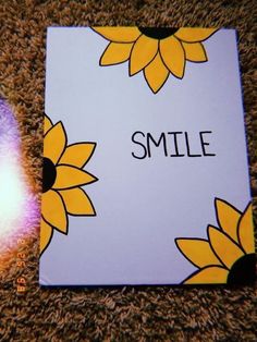 an open book with sunflowers on it and the word smile next to it