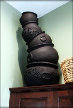 a black vase sitting on top of a wooden dresser