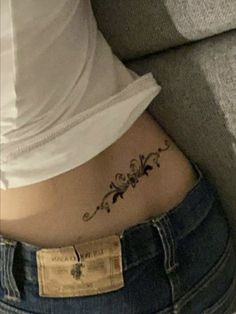 a woman's stomach with a small tattoo on her lower back and the word love written