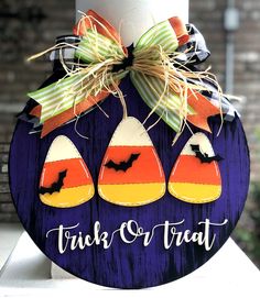 a trick or treat sign with bats and pumpkins hanging from it's side