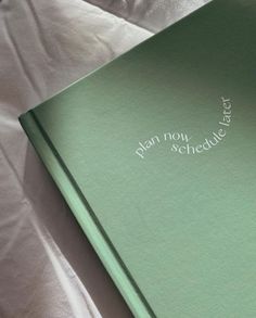 an open green book sitting on top of a white bed sheet with the words, when no schedule