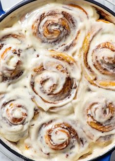 a pan filled with cinnamon rolls covered in icing