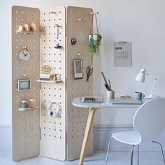 a room divider made out of pegboards with various items on it and a table