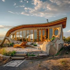 an unusual house built into the side of a hill with a slide in front of it