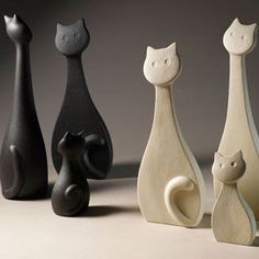 five black and white cat figurines are lined up