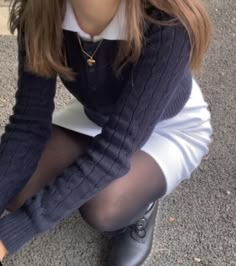 a woman sitting on the ground with her legs crossed wearing tights and socks,