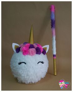 a paper ball with a unicorn's face on it next to a straw stick