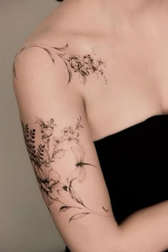 a woman with a flower tattoo on her arm and shoulder is looking at the camera