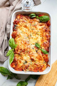 a casserole dish with spinach and cheese in it on a marble counter top