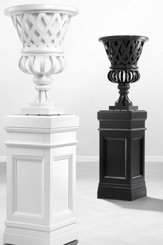 three black and white vases sitting next to each other on top of pedestals