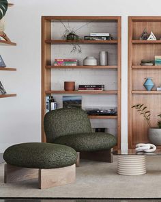 a living room filled with furniture and bookshelves next to a wall mounted book shelf