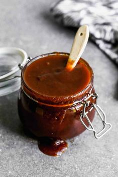 a jar of barbecue sauce with a wooden spoon in it