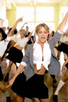 a group of young women dancing together in a dance studio with their arms up and legs spread out