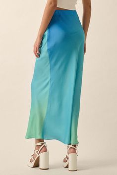 Ombre satin maxi skirt. High waist. Bias cut. Invisible zipper side closure. Straight silhouette. Ankle length. Relaxed fit. 100% Polyester. Imported. Designed in LA. Model wears size S. Chic Blue Satin Bottoms, Blue Silk Wide Leg Bottoms, Blue Silk Wide-leg Bottoms, Summer Satin Midi Bottoms, Relaxed Satin Maxi Skirt, Satin Maxi Skirt With Bias Cut, Satin Bias Cut Maxi Skirt, Maxi Length Satin Skirt With Bias Cut, Flowy Wide Leg Skirt With Bias Cut