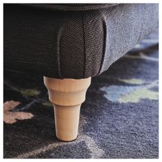 a close up view of a footstool on a bed with blue and green carpet