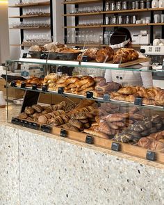 a bakery filled with lots of different types of breads and pastries on display