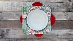 a white plate and red placemat on a wooden table with wood boards in the background