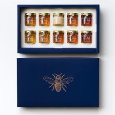 twelve jars of honey in a blue box