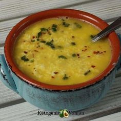 a blue bowl filled with soup on top of a wooden table