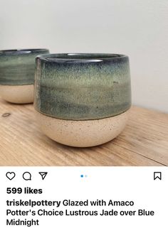 two cups sitting on top of a wooden table next to each other, one is green and the other is blue