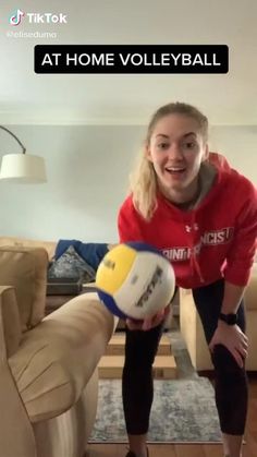 a woman holding a ball in her right hand with the words at home volleyball on it