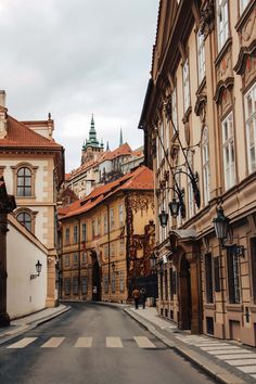 an empty street with old buildings in the background