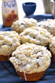 muffins with icing sitting on a plate next to a bottle of milk