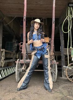 a woman sitting on top of a horse drawn carriage in an old fashioned barn area