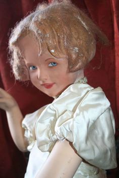 a close up of a doll wearing a white dress