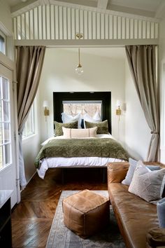 a large bed sitting in the middle of a bedroom next to a window with curtains