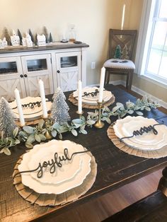 the table is set for christmas dinner with plates and napkins on top of it