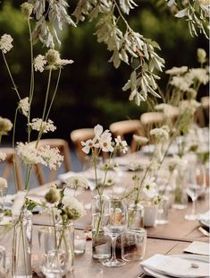 the table is set with white flowers and place settings for dinner guests to sit at