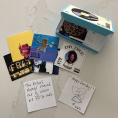 several post it notes are on the counter next to a box with pictures and writing