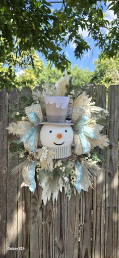 a wooden fence with a snowman decoration on it