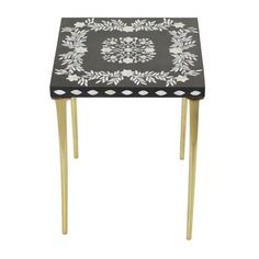 a black and white patterned table with gold legs