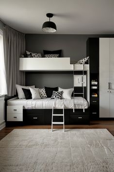 a white and black bedroom with bunk beds, drawers, ladders and rug on the floor