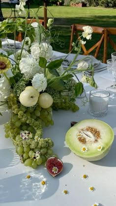 the table is set with flowers, fruit and watermelon for a wedding reception