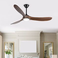 a living room with a ceiling fan in the middle of it and pictures on the wall