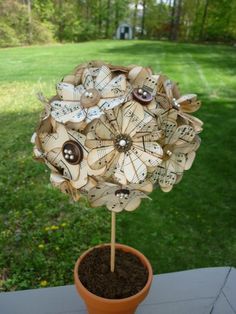 a potted plant that has been made out of old sheet music sheets and buttons