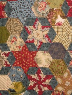 an old quilt with many different designs on it's sides, including hexagonals