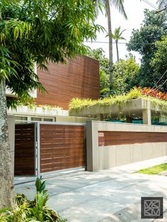 a modern house with wooden garage doors and plants on the roof