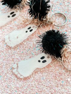 three black and white spiky halloween decorations on pink glittered surface with keychains