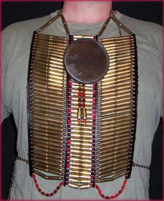 a man wearing a necklace made out of gold and red beads with a mirror on it